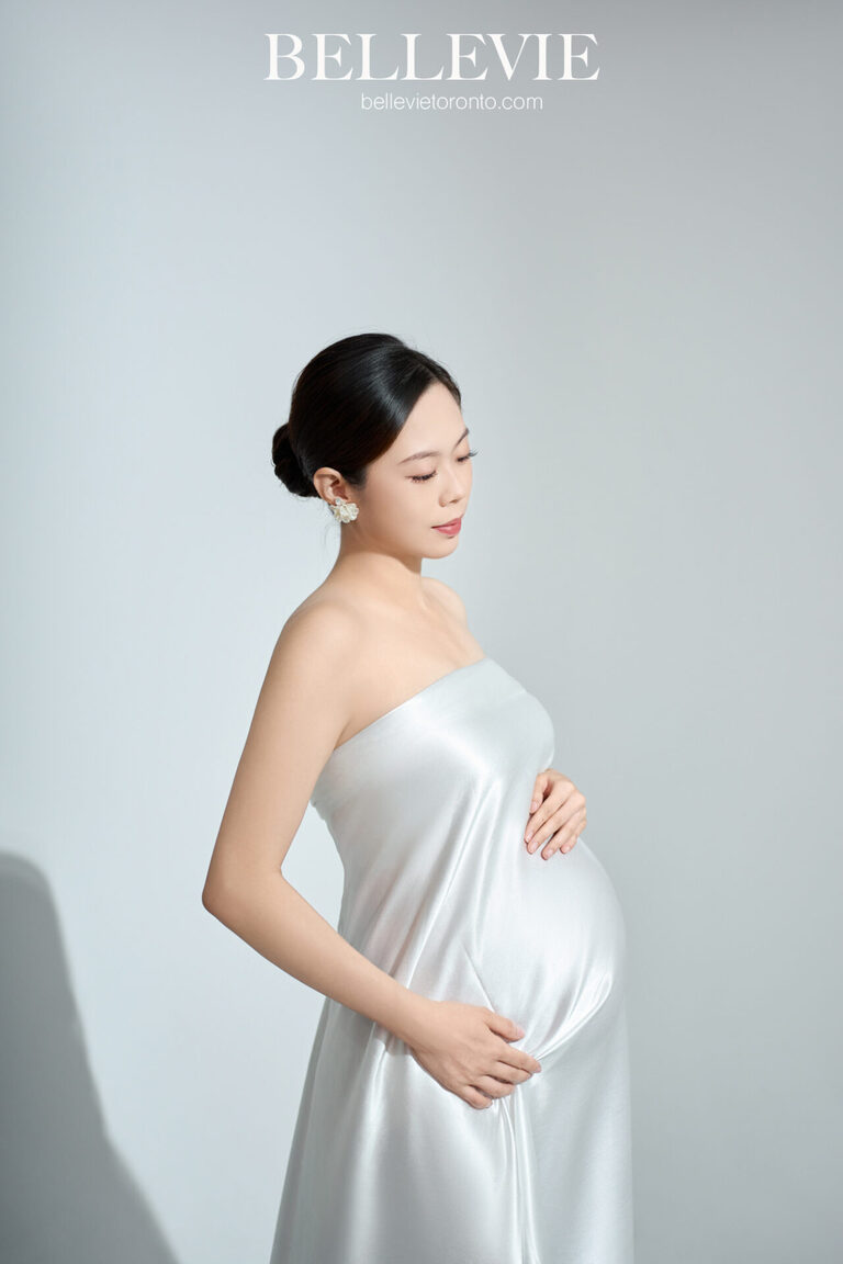 Expectant mother silhouetted against a backdrop of cascading light