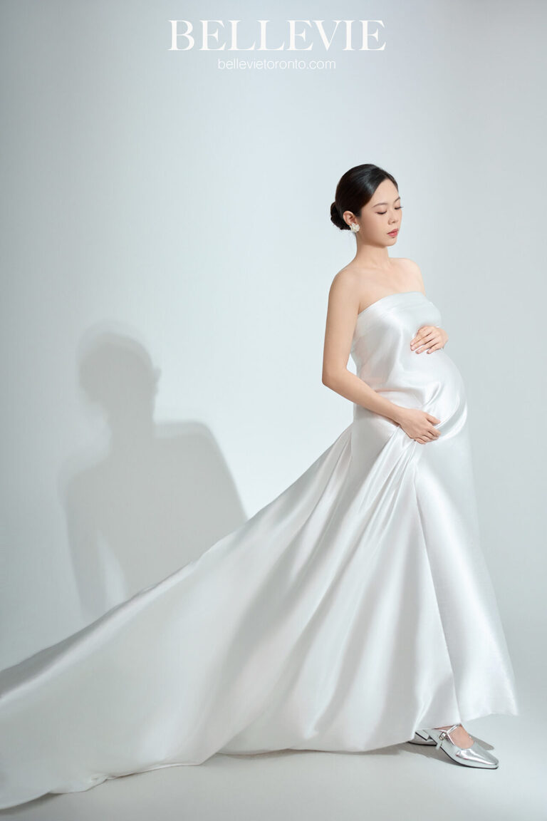 Maternity portrait with dramatic lighting highlighting the baby bump