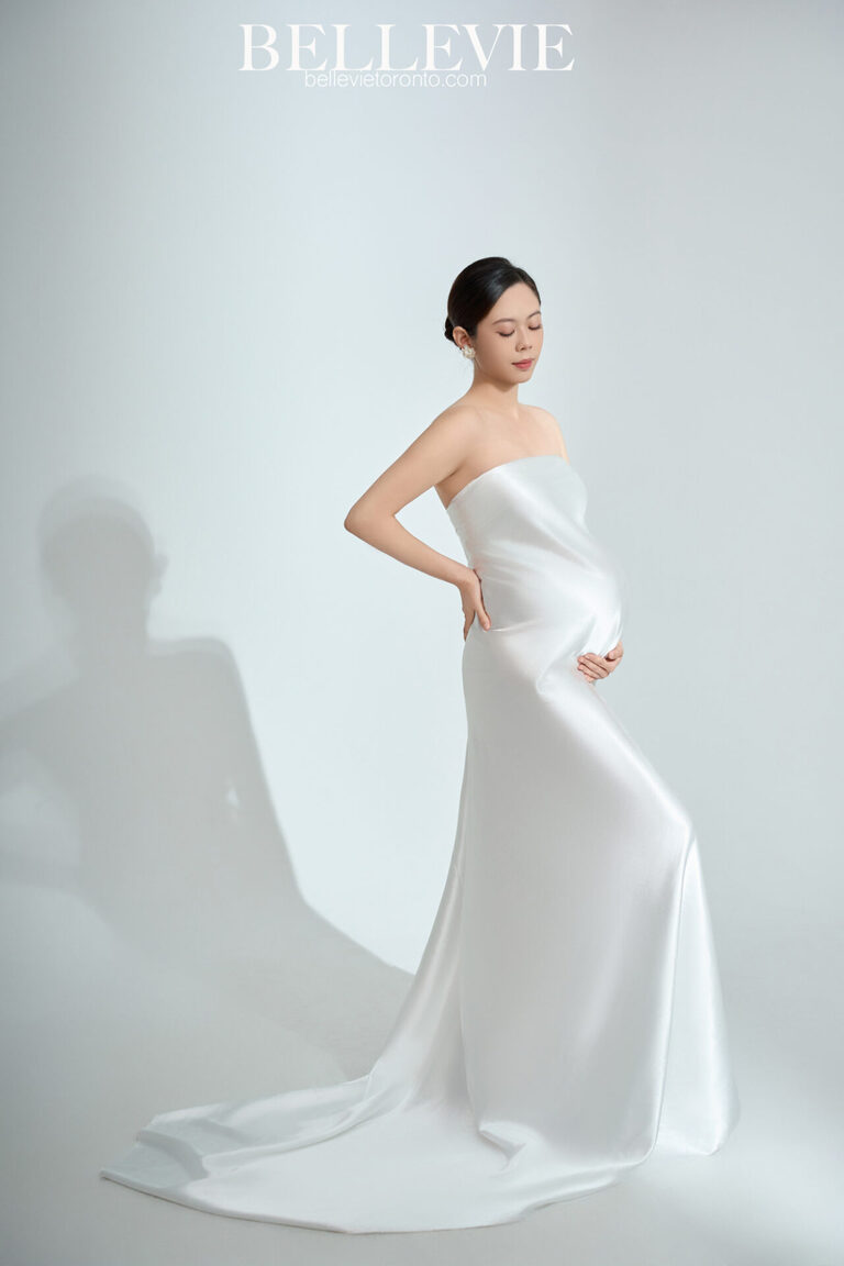 Mother-to-be posing gracefully under a focused light beam